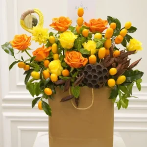 Crimson Sunset Bouquet with orange and yellow roses in a brown gift bag