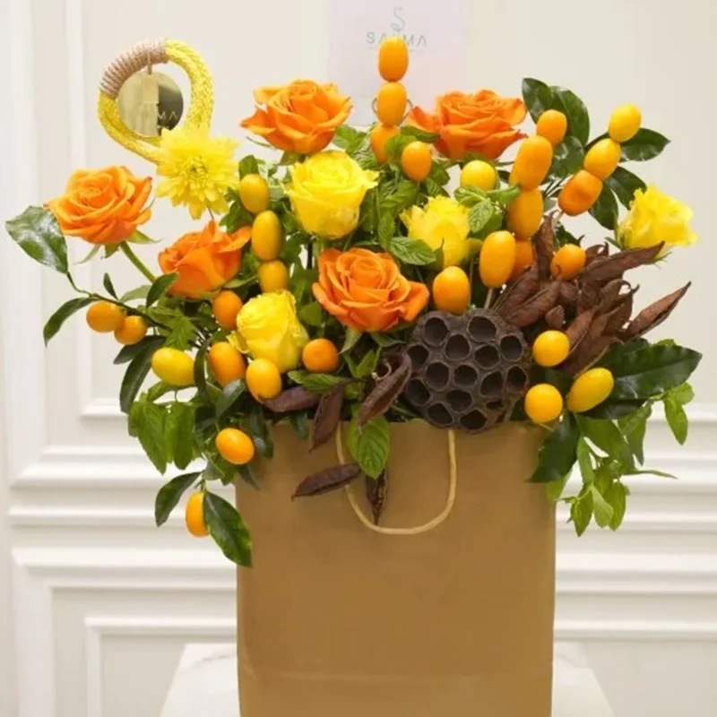 Crimson Sunset Bouquet with orange and yellow roses in a brown gift bag