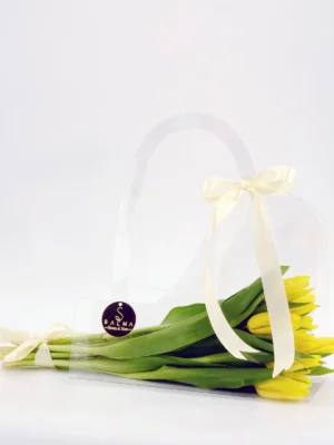 Yellow Tulip Bag arrangement in a transparent acrylic handbag with ivory ribbons
