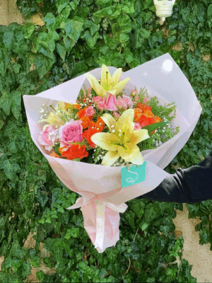Colorful bouquet of lilies with pink and orange roses