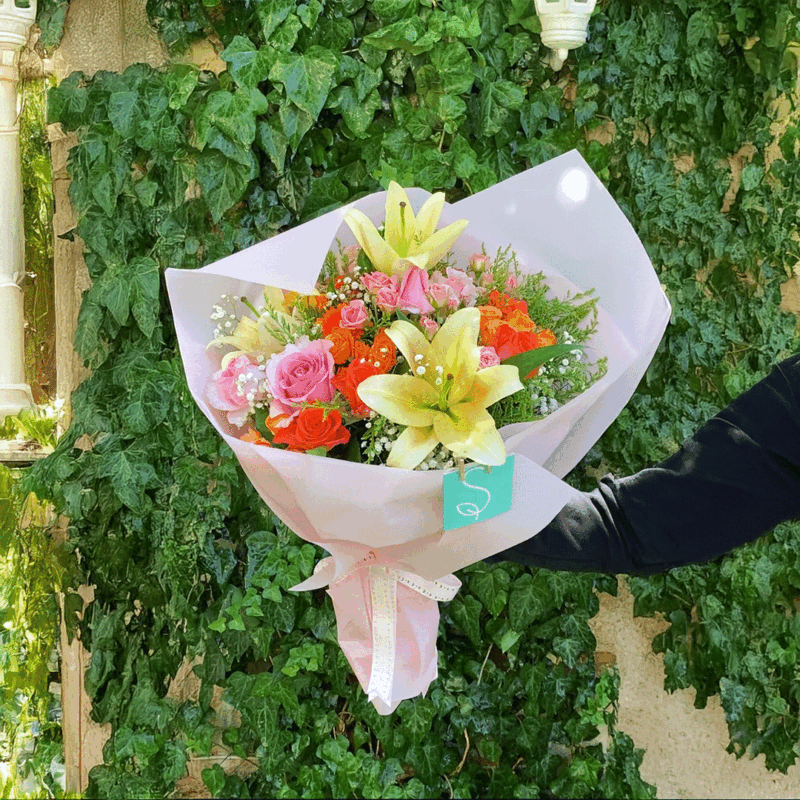 Colorful bouquet of lilies with pink and orange roses