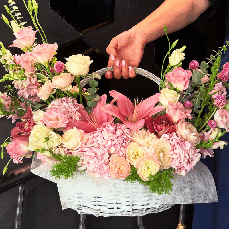 Pink flower basket with lilies, white roses, and hydrangea