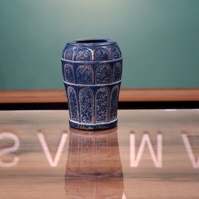 Ornate Distressed Blue Ceramic Vase with Embossed Patterns on a Mirrored Surface